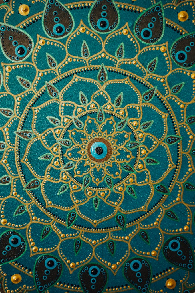 Detailed dot painting mandala artwork on teal background showcasing vibrant, intricate patterns.